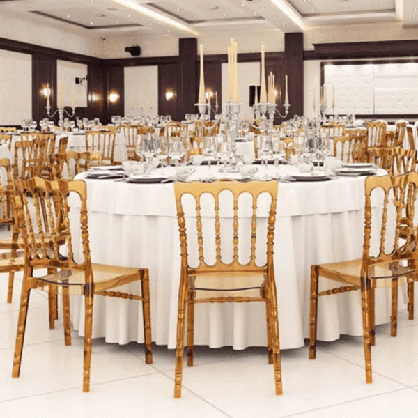 Salón elegante con mesas redondas y sillas doradas para eventos.