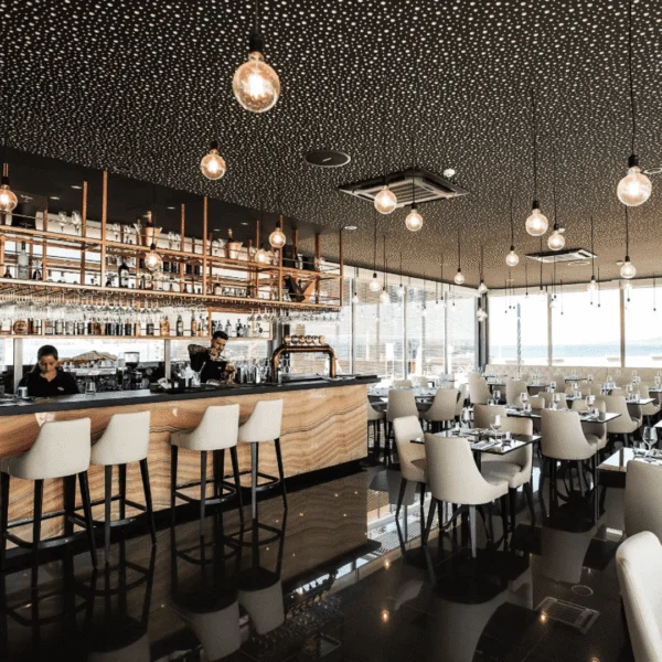 Restaurante moderno con barra y sillas blancas de diseño.