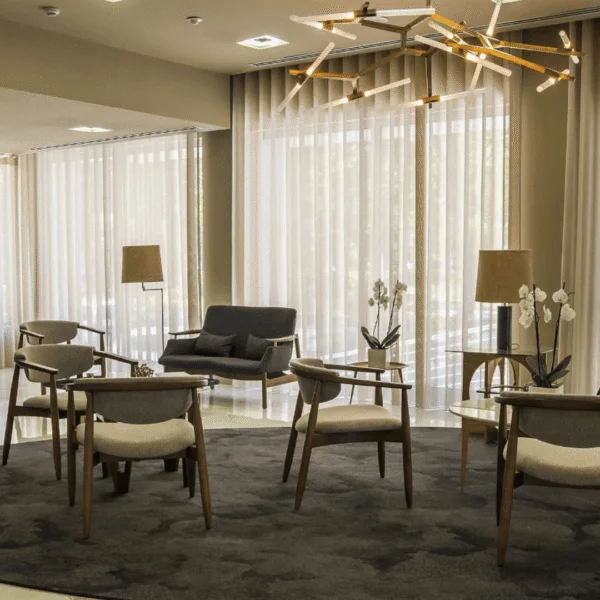 Lobby de hotel con sillones modernos y lámparas colgantes.