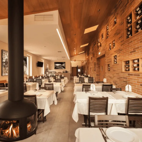 Restaurante con mobiliario de madera y chimenea de estilo moderno-rústico.